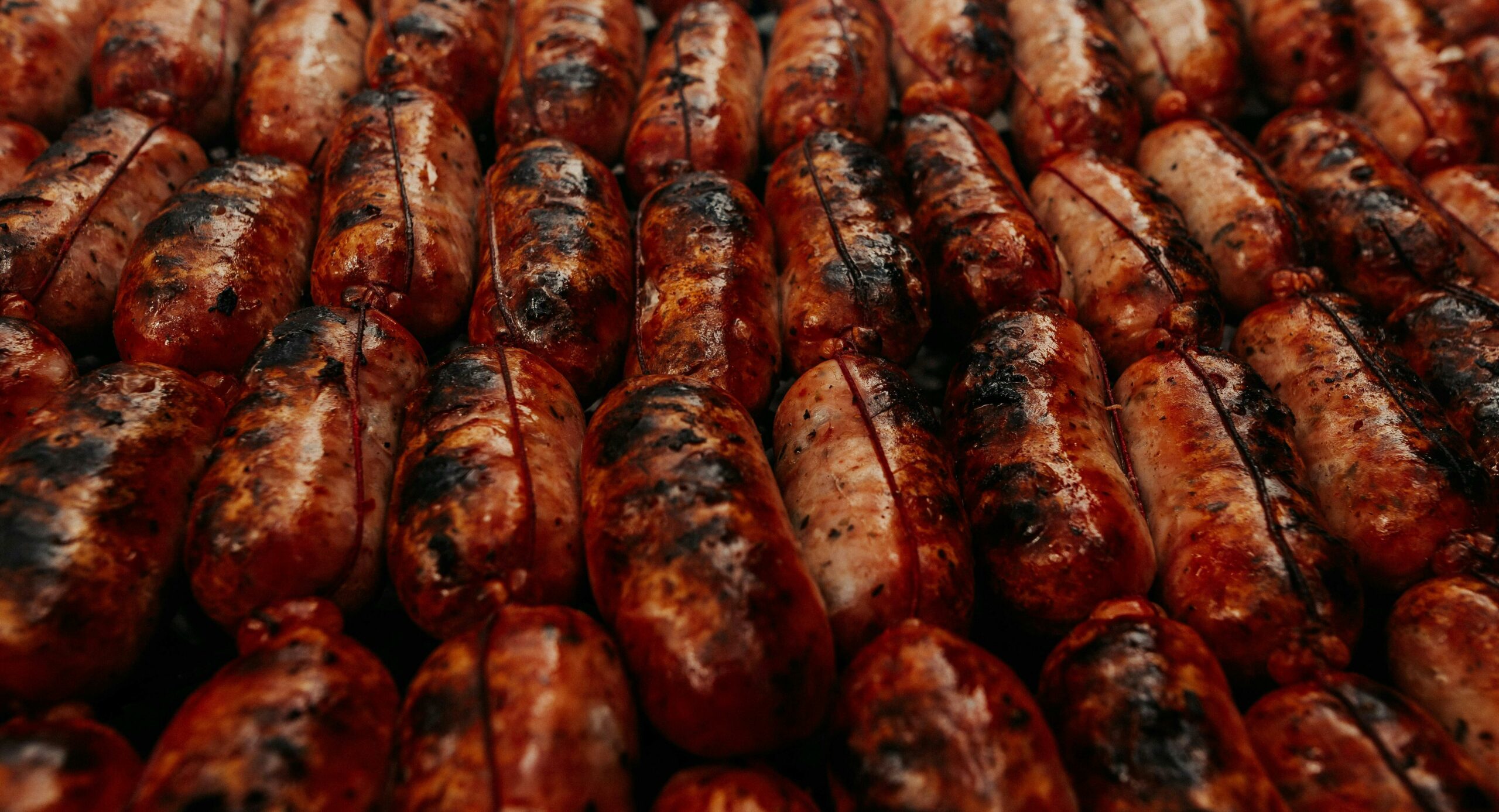 A vivid close-up of Fresh Lap Xuong prepared in the River Delta style, showing the moist and tender texture of the Vietnamese sausage before being pan-seared