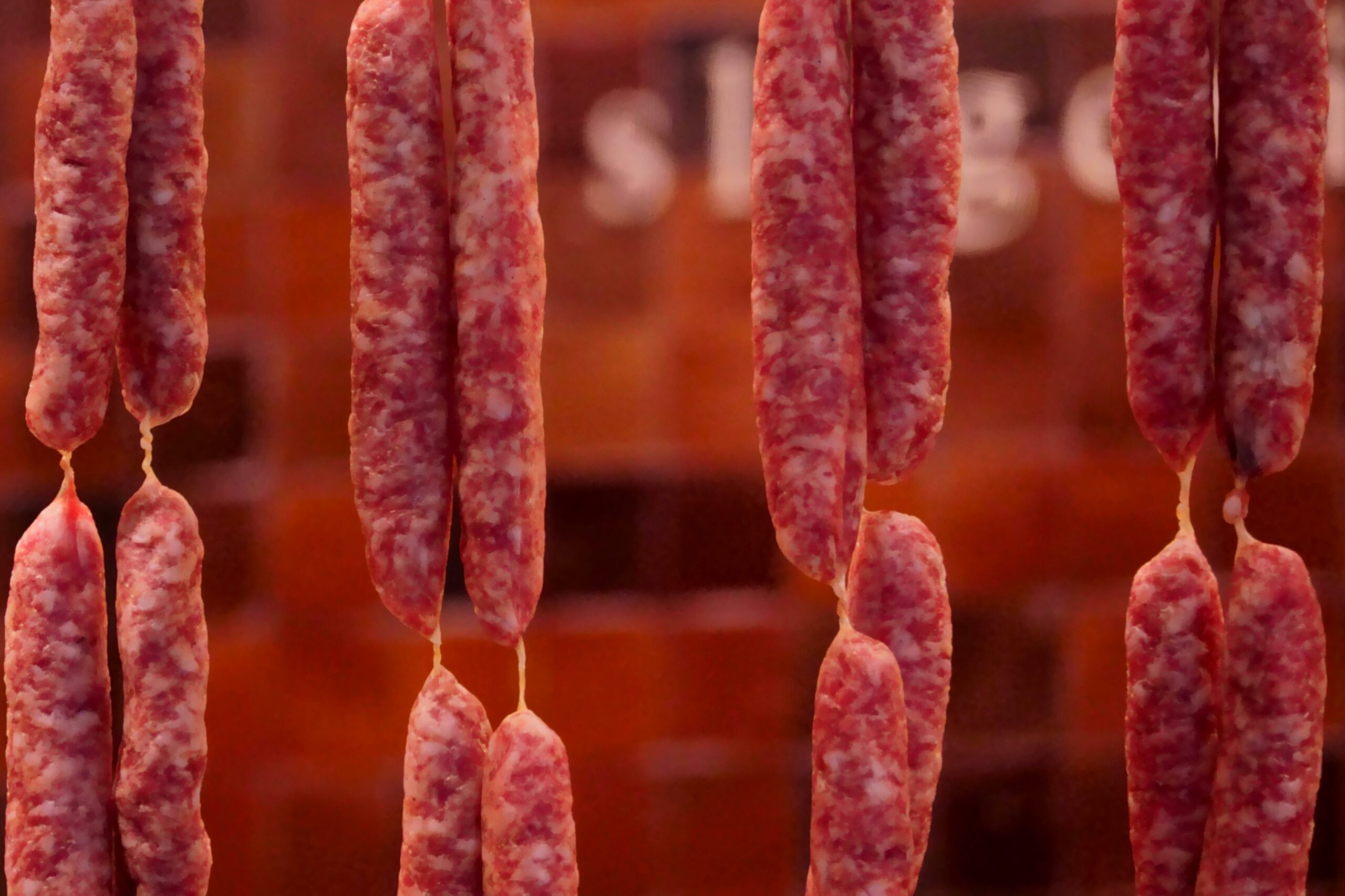 An informative and artistic close-up of a premium Vietnamese sausage (lap xuong), explaining what is Vietnamese sausage through its distinctive red texture and aromatic ingredients.