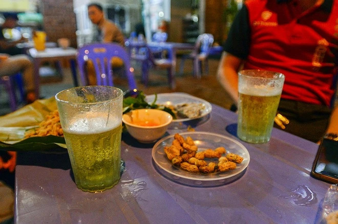Travelers enjoying bia hoi Hanoi on busy streets with local residents
