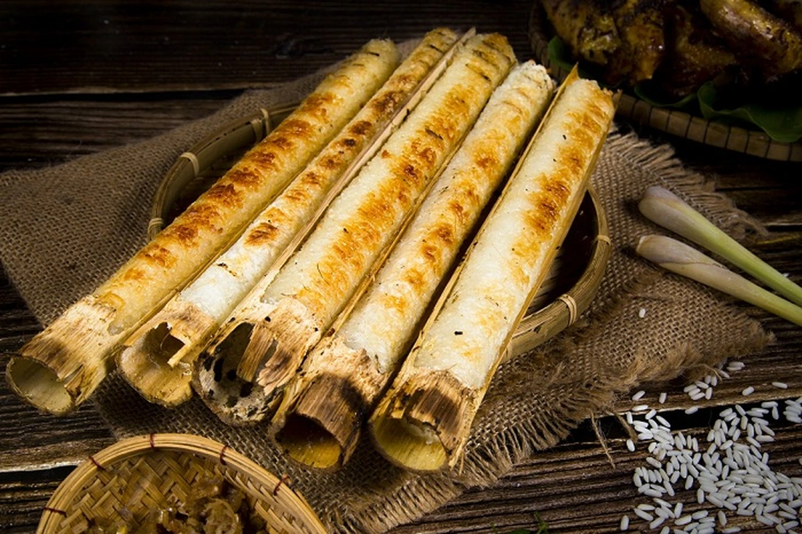 Vietnamese cơm lam cooked inside bamboo tubes over an open fire