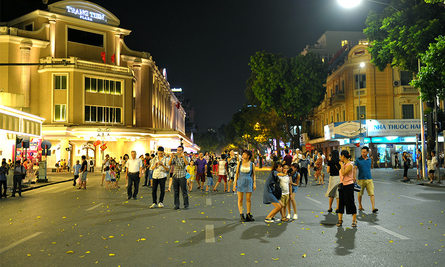 Visitors walking through a neighbourhood in central Hanoi