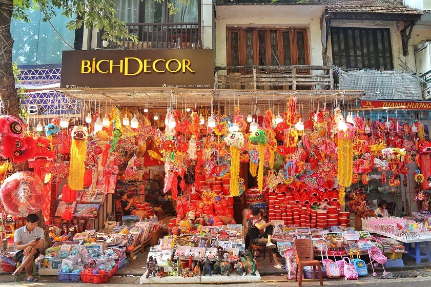Travelers browsing local souvenirs in Hanoi’s Old Quarter