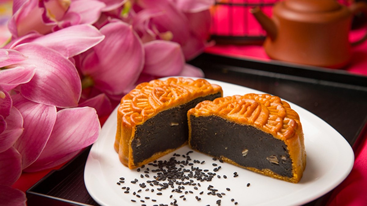Sliced Vietnamese mooncake with a dark roasted black-sesame filling