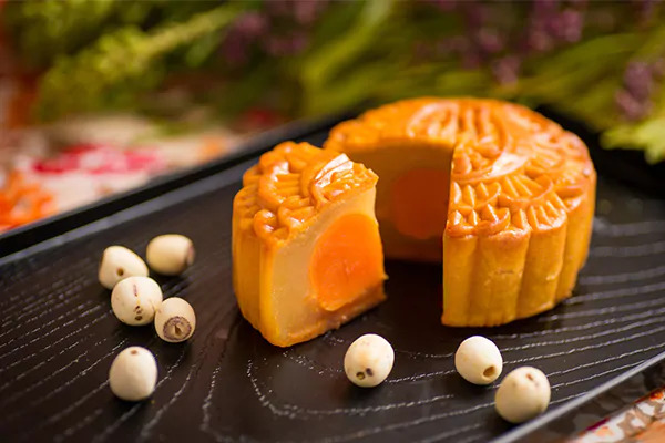 Sliced lotus-seed mooncake served with a cup of Vietnamese lotus tea