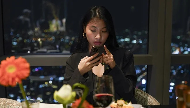 Diner taking a discreet food photo without disturbing other guests