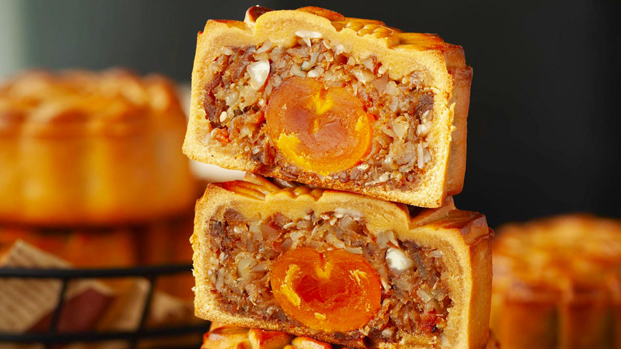 Sliced thập cẩm mooncake filled with nuts, seeds, sausage and candied winter melon