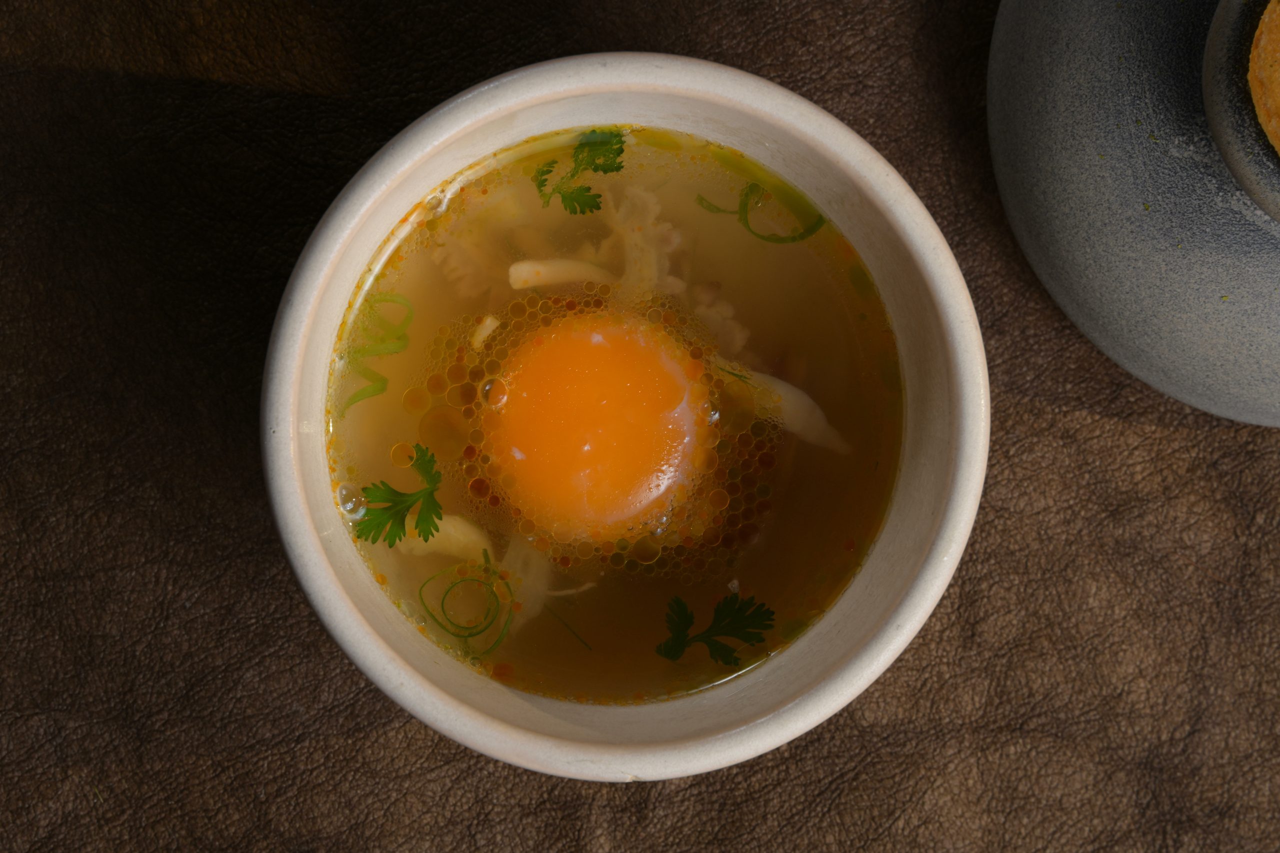 Chicken phở with confit egg yolk and Đông Tảo chicken at Chapter Dining
