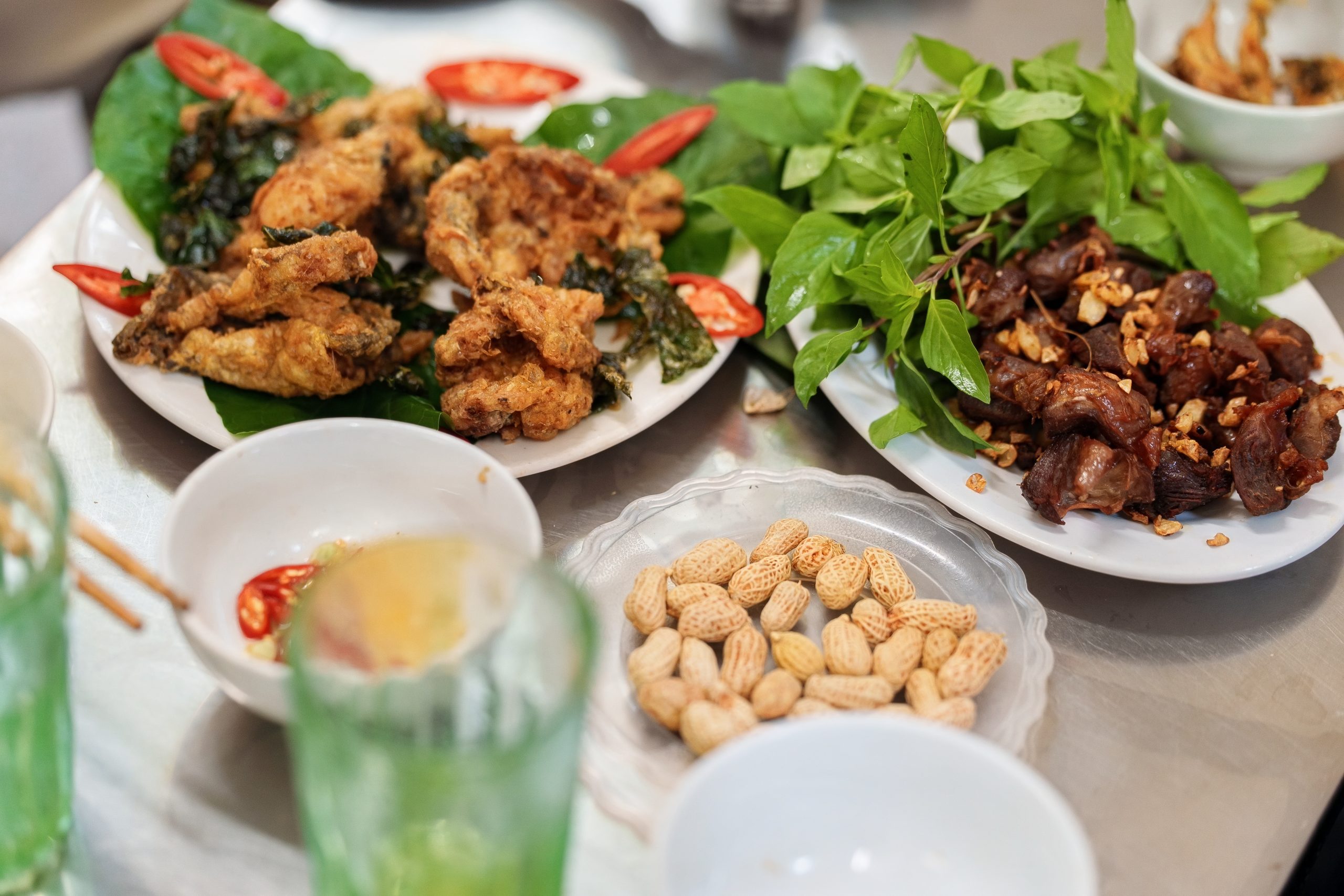 At a Hanoi Bia Hơi spot, boiled peanuts, fried frog legs and Vietnamese fermented pork offered Chef Sylvain a glimpse into the city’s traditions of eating and drinking