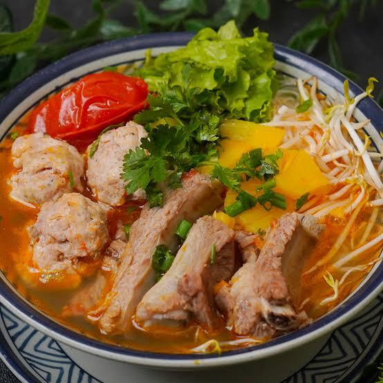 Bun moc suon chua with pork ribs, meatballs, rice noodles and tomatoes.