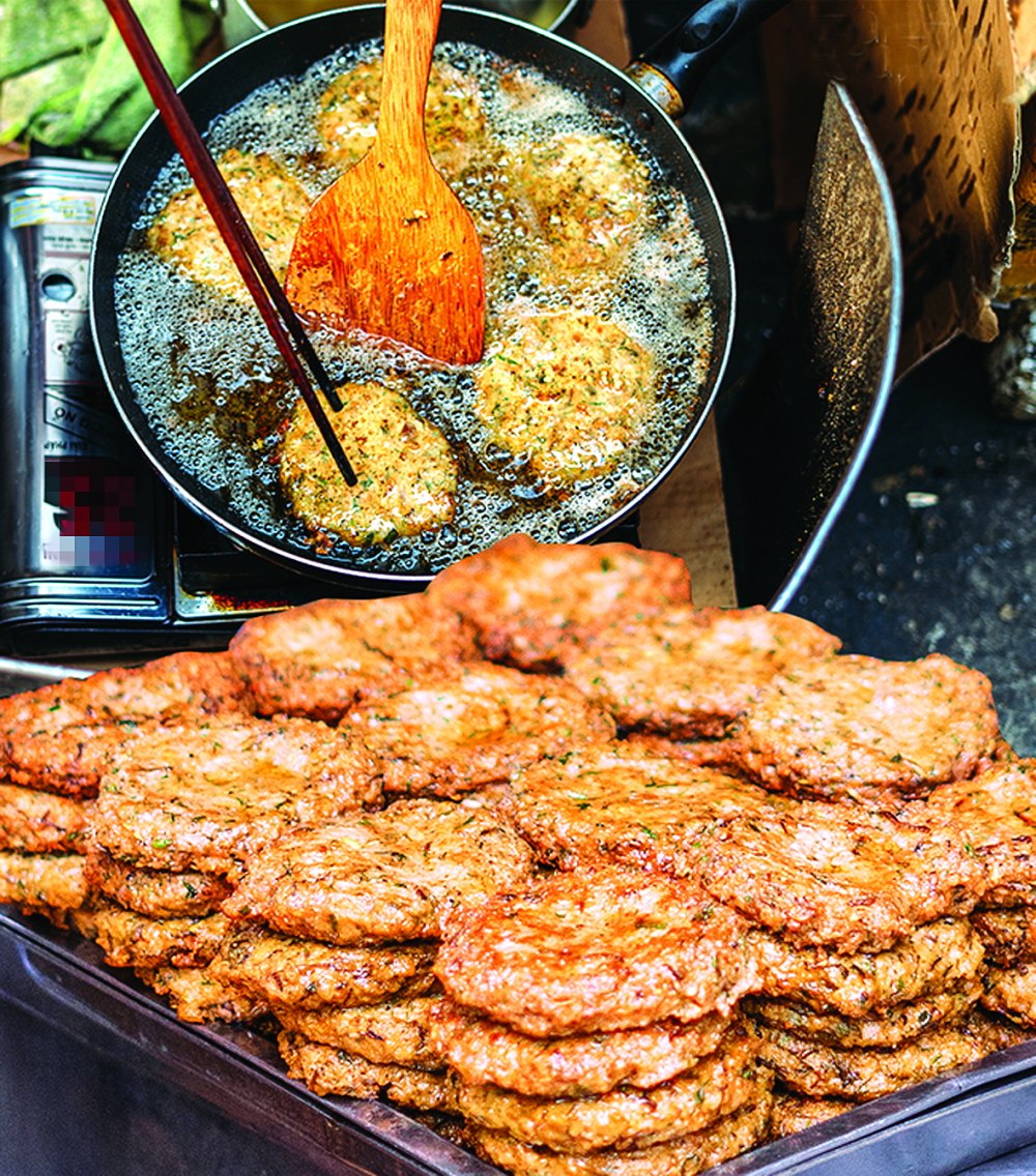 Golden chả rươi patties served with fresh herbs and dipping sauce