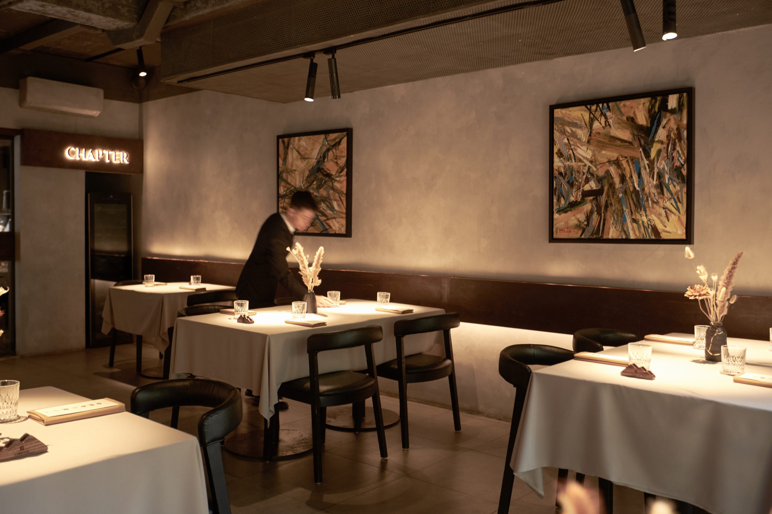A seasonal tasting menu course with Chapter Dining’s open kitchen in the background