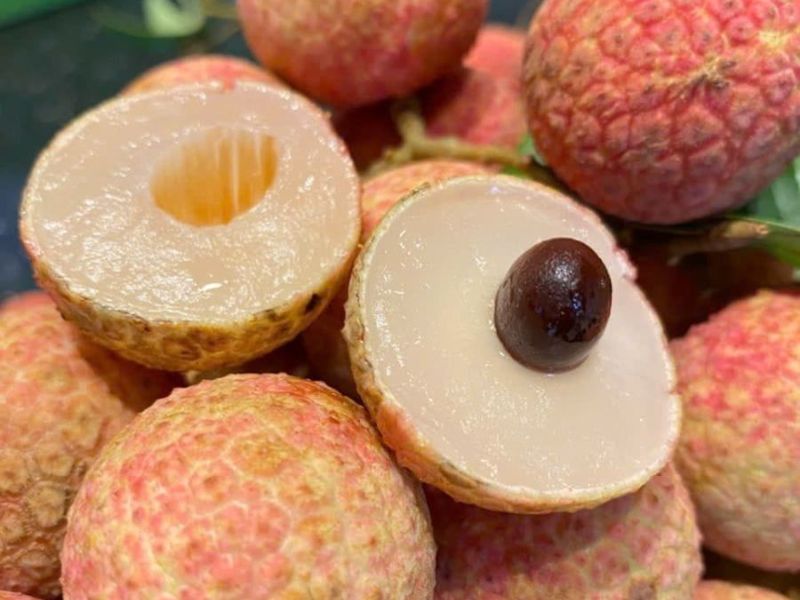 Whole and peeled lychees showing their white flesh