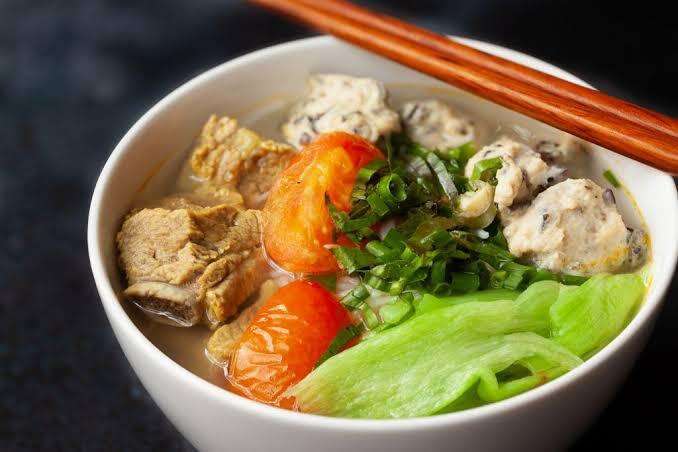 Close-up of pork ribs and mushroom-flecked pork meatballs in noodle broth