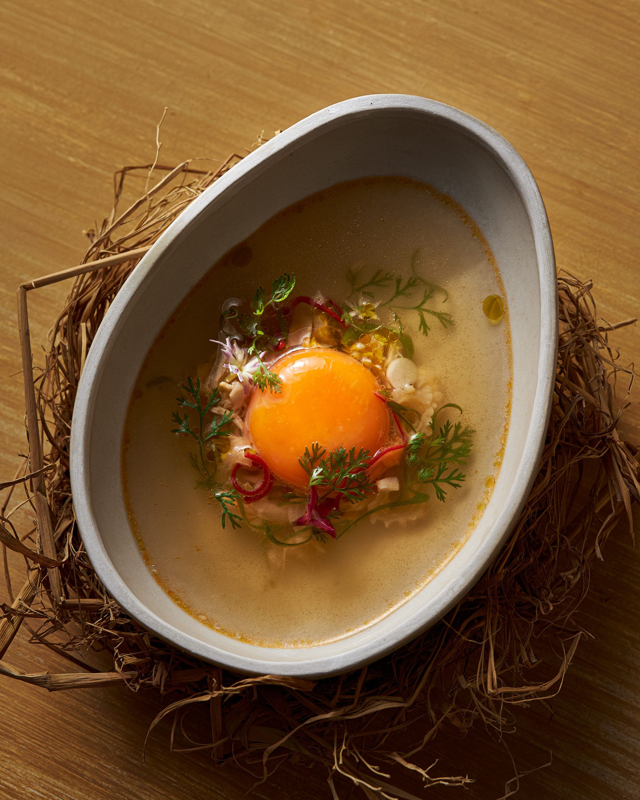 Private dining room at Chapter presenting Chicken phở with egg yolk and Đông Tảo chicken feet